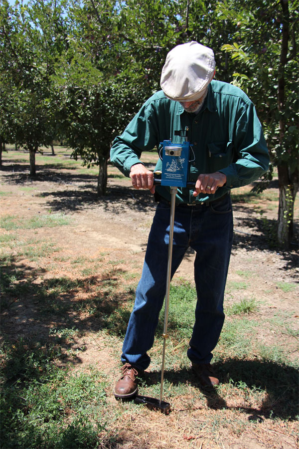 man inserting a drill into the ground