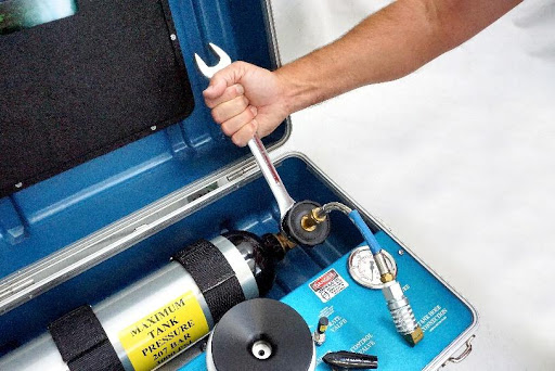 Using a wrench to twist the plastic wheel nut on the fitting counter-clockwise